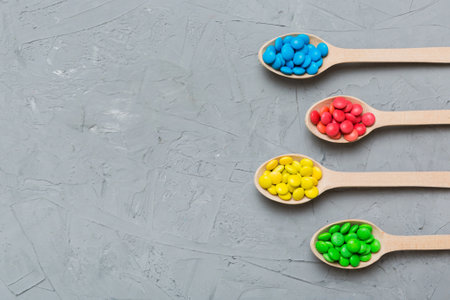 delicious colorful sweet candies on spoon on colored background . Confectionery decor top view with copy space.の写真素材