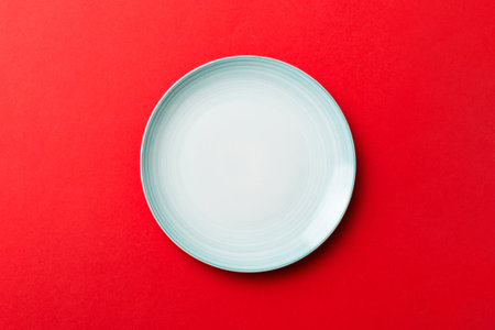 Top view of isolated of colored background empty round blue plate for food. Empty dish with space for your design.の写真素材