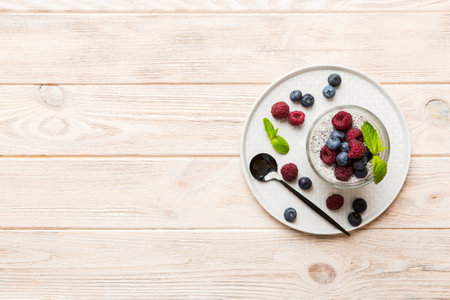 Healthy breakfast or morning with chia seeds vanilla pudding raspberry and blueberry berries on table background, vegetarian food, diet and health concept. Chia pudding with raspberry and blueberry.の写真素材