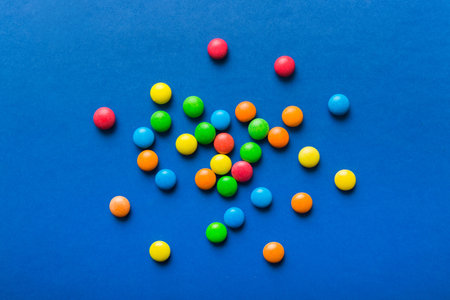 Mixed collection of colorful candy, on colored background. Flat lay, top view. frame of colorful chocolate coated candy.の写真素材