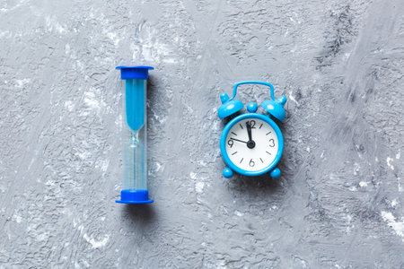 hourglass and clock as time passing concept for business deadline, urgency and running out of time.