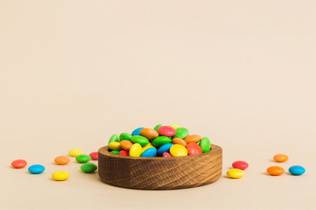 Multicolored candies in a bowl on a colored background. birthday and holiday concept. Top view with copy space.の写真素材