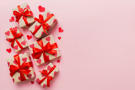 Top view photo of valentine's day decorations gift box with red ribbon bow on colored background....