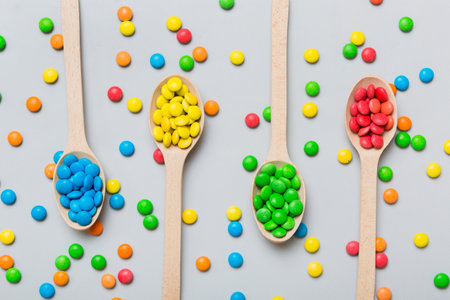delicious colorful sweet candies on spoon on colored background . Confectionery decor top view with copy space.の写真素材