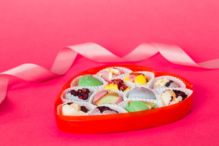 Valentine day composition: sweet candy, with gift boxes with bow and red felt hearts, photo...