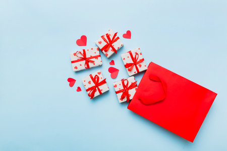 Gift boxes pop out from paper bag top view on colored background. bag packing handmade boxes fall out Concept of holidays, shopping, sale, discounts. Top view, flat lay.