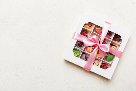Box with sweet chocolate candies on color background, Various candy sweets. Valentine's day gift...