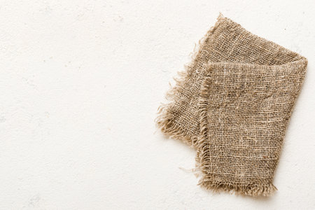 Old burlap fabric napkin, sackcloth on table background. top view with copyspace.の写真素材