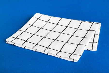 top view with white empty kitchen napkin isolated on table background. Folded cloth for mockup with...