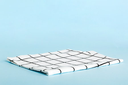 top view with white empty kitchen napkin isolated on table background. Folded cloth for mockup with...