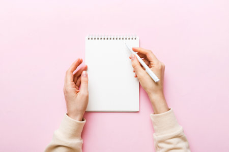 Woman hand with pencil writing on notebook. Woman working on office table. Female hand holding...