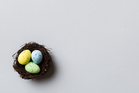 Colorful easter eggs in nest on table background with copy space top view.の写真素材