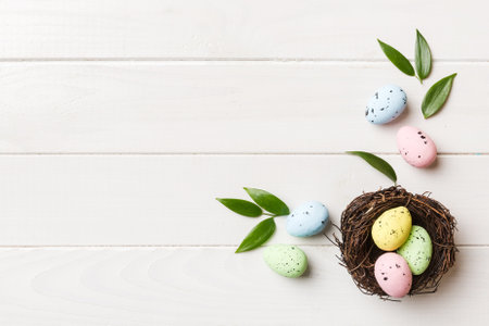Colorful easter eggs in nest on table background with copy space top view.の写真素材