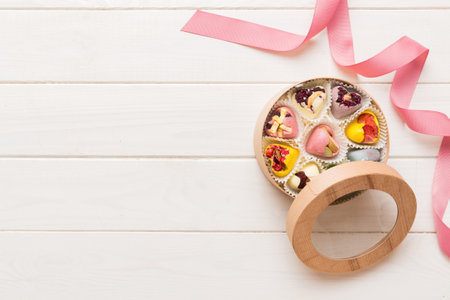 Holiday composition: sweet candy, with gift boxes with bow and chocolate hearts, photo template, background. Top View with copy space on colored background.の写真素材