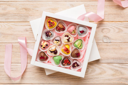Holiday composition: sweet candy, with gift boxes with bow and chocolate hearts, photo template,...