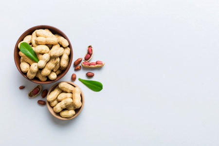 Fresh healthy peanuts in bowl on colored table background. Top view Healthy eating bertholletia concept. super foods.の写真素材