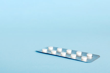 Blister package with aspirin on color background. Medicine pills on a light background. Medicines and prescription pills flat lay background. white medical tablets in blister.の写真素材