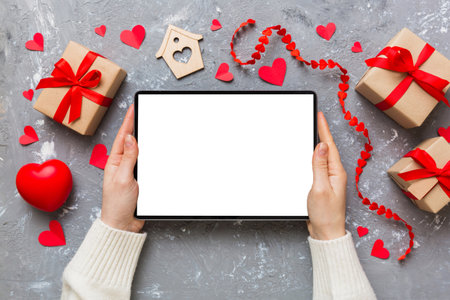 Female hands using a laptop for Valentine's day background, gift box and envelope, hearts.