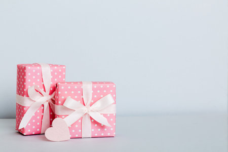gift box with red bow and red heart on colored background. perspective view. flat lay.
