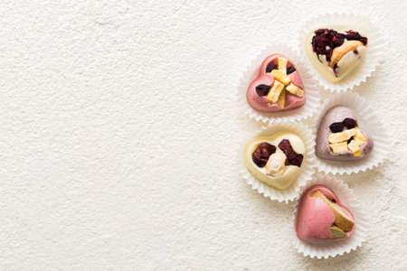 chocolate sweets in the form of a heart with fruits and nuts on a colored background. top view with space for text, holiday concept.の写真素材