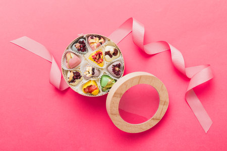 Holiday composition: sweet candy, with gift boxes with bow and chocolate hearts, photo template, background. Top View with copy space on colored background.の写真素材