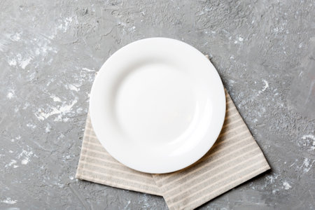 Top view on colored background empty round white plate on tablecloth for food. Empty dish on napkin with space for your design.の写真素材
