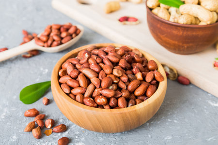 Fresh healthy peanuts in bowl on colored table background. Top view Healthy eating bertholletia...