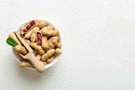 Fresh healthy peanuts in bowl on colored table background. Top view Healthy eating bertholletia...