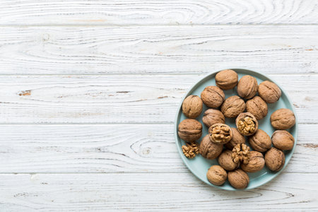 Fresh healthy walnuts in bowl on colored table background. Top view Healthy eating bertholletia concept. super foods.の写真素材