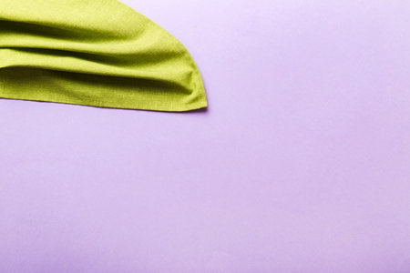top view with green kitchen napkin isolated on table background. Folded cloth for mockup with copy space, Flat lay. minimal style.の写真素材