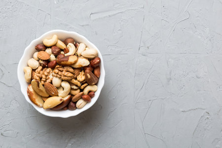 mixed nuts in bowl. Mix of various nuts on colored background. pistachios, cashews, walnuts, hazelnuts, peanuts and brazil nuts.の写真素材