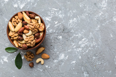 mixed nuts in bowl. Mix of various nuts on colored background. pistachios, cashews, walnuts, hazelnuts, peanuts and brazil nuts.の写真素材