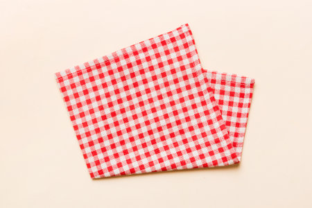 top view with red empty kitchen napkin isolated on table background. Folded cloth for mockup with...