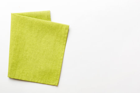 top view with green kitchen napkin isolated on table background. Folded cloth for mockup with copy space, Flat lay. minimal style.の写真素材