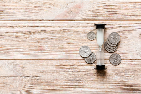 Deadline and time is money concept with hourglass and US coins currency. sand clock time saving concept.の写真素材