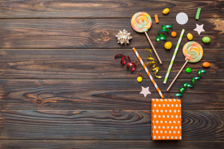 gift box in full corner of assorted traditional candies falling out on colored background with copy space. Happy Holidays sale concept.の写真素材