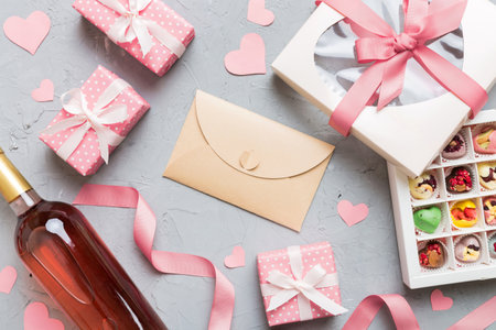 top view photo of st valentine day decor shopping, bag, wine, bottle, envelope, gift, box, candy and red heart on colored background with empty space. frame background.の写真素材