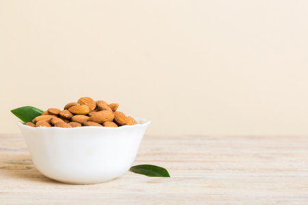 Fresh healthy Almond in bowl on colored table background. top view.の写真素材