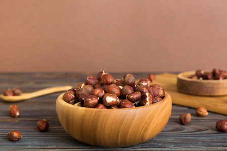 Wooden bowl full of hazelnuts on table background. Healthy eating concept. super foods.の写真素材