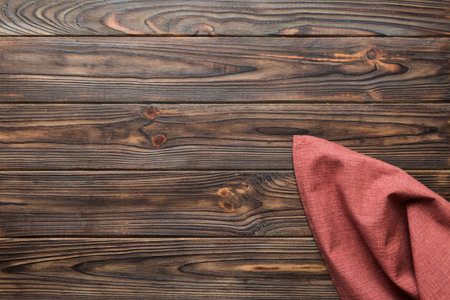 top view with red empty kitchen napkin isolated on table background. Folded cloth for mockup with...