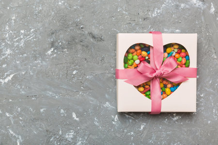 Box with sweet chocolate candies on color background, Various candy sweets. Valentine's day gift box. Top view flat lay with copy space.の写真素材