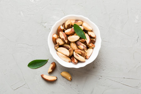 Fresh healthy Brazil nuts in bowl on colored table background. Top view Healthy eating bertholletia concept. super foods.の写真素材