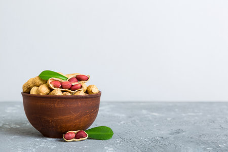 Fresh healthy peanuts in bowl on colored table background. Top view Healthy eating bertholletia concept. super foods.の写真素材