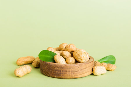 Fresh healthy peanuts in bowl on colored table background. Top view Healthy eating bertholletia concept. super foods.の写真素材