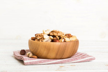 mixed nuts in bowl. Mix of various nuts on colored background. pistachios, cashews, walnuts, hazelnuts, peanuts and brazil nuts.の写真素材