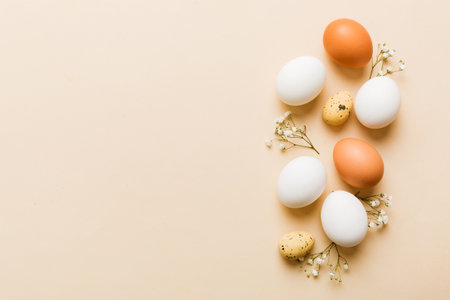 Happy Easter composition. Easter eggs on colored table with gypsophila. Natural dyed colorful eggs background top view with copy space.の写真素材