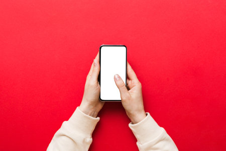 Top view of woman hands holding smart phone with blank copy space screen for your text message or information content. woman hand using phone white screen on top view.の写真素材