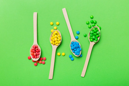 delicious colorful sweet candies on spoon on colored background . Confectionery decor top view with copy space.の写真素材