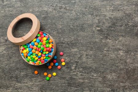 Set of different sweet candy in a paper box with a satin ribbon on a colored background. holiday concept.の写真素材