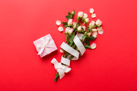 design concept with pink rose flower and gift box on colored table background top view. Happy Holiday, Mother's day, birthday concept. Romantic flat lay composition.の写真素材